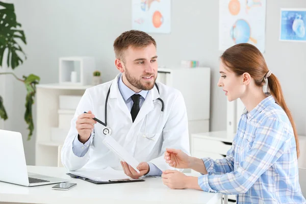 Médico do sexo masculino trabalhando com paciente do sexo feminino na clínica — Fotografia de Stock