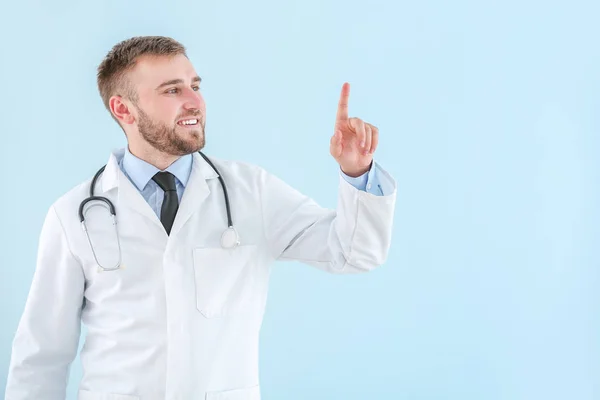 Retrato de médico masculino mostrando algo no fundo de luz — Fotografia de Stock