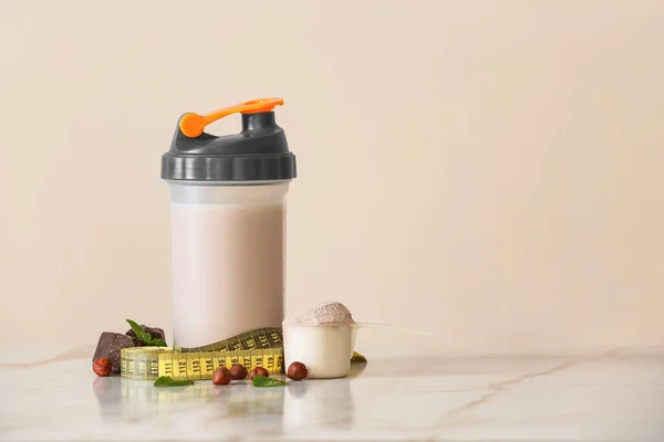 Fles proteïne shake met meetlint op lichttafel — Stockfoto