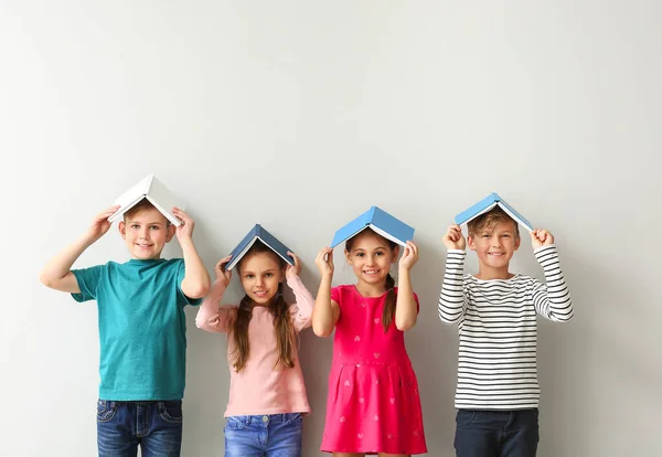 Carino bambini piccoli con libri su sfondo grigio — Foto Stock