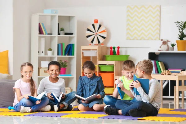 Bonito crianças lendo livros dentro de casa — Fotografia de Stock