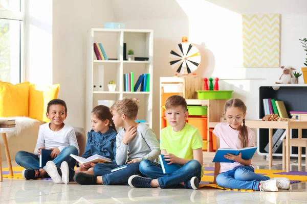 Bonito crianças lendo livros dentro de casa — Fotografia de Stock