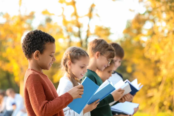 Petits enfants mignons lisant des livres à l'extérieur — Photo