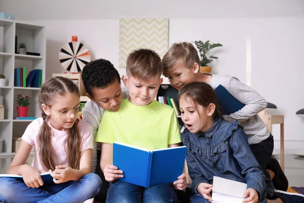 Niedliche kleine Kinder lesen Buch drinnen — Stockfoto