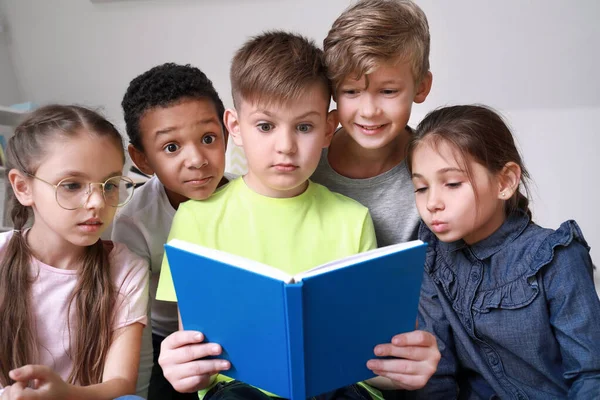 Petits enfants surpris lisant le livre à l'intérieur — Photo