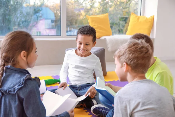 Lindos niños leyendo libros en el interior — Foto de Stock