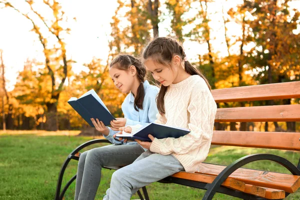 Leuke kleine meisjes lezingsboeken in park — Stockfoto