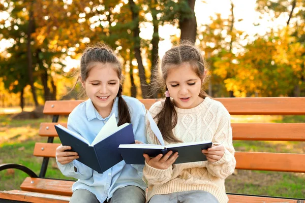 Niedliche kleine Mädchen lesen Bücher im Park — Stockfoto