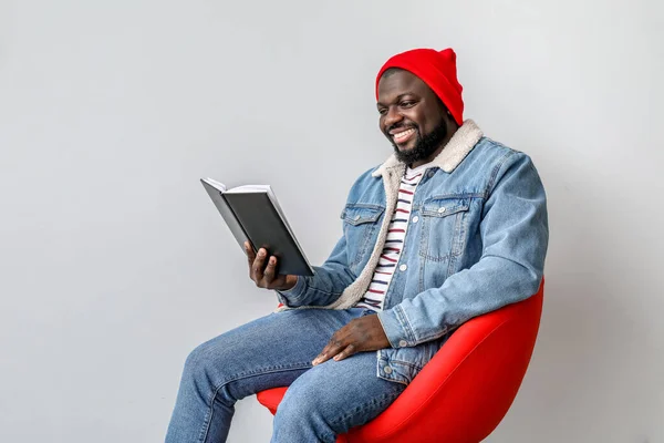 Africano-americano homem leitura livro sobre luz de fundo — Fotografia de Stock