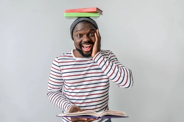 Surpris homme afro-américain lecture livre sur fond clair — Photo