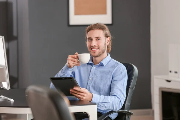 Knappe zakenman drinken koffie in office — Stockfoto