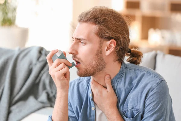 Uomo malato con inalatore d'asma a casa — Foto Stock