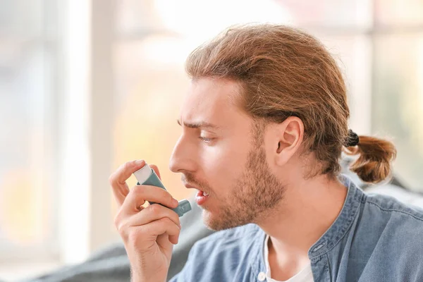 Chory człowiek z inhalatorem astmy w domu — Zdjęcie stockowe