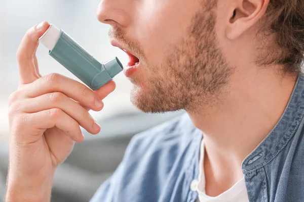 Chory człowiek z inhalatorem astmy w domu, zbliżenie — Zdjęcie stockowe