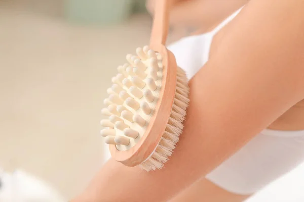 Beautiful young woman with massage brush in bathroom, closeup — Stock Photo, Image