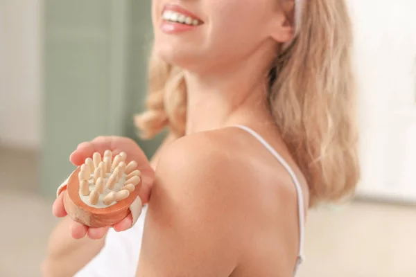 Krásná mladá žena s masážní kartáč v koupelně, closeup — Stock fotografie