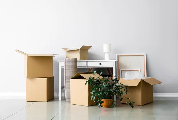 Cajas de cartón con pertenencias y mesa en piso nuevo en día de mudanza — Foto de Stock