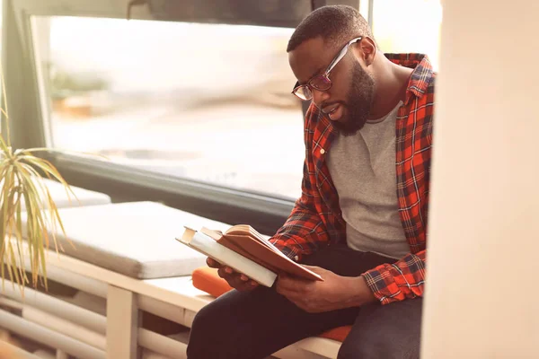 Estudiante afroamericano leyendo libro mientras se prepara para el examen en la biblioteca — Foto de Stock