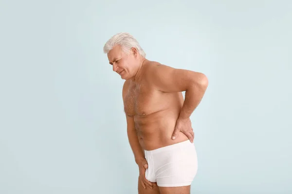 Mature man with urologic disease on light background — Stock Photo, Image