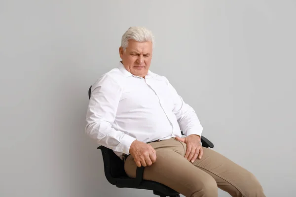 Uomo maturo con malattia urologica su sfondo chiaro — Foto Stock