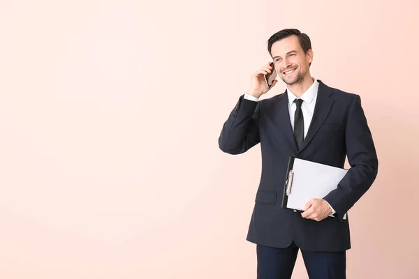 Masculino agente imobiliário falando por telefone móvel na cor de fundo — Fotografia de Stock