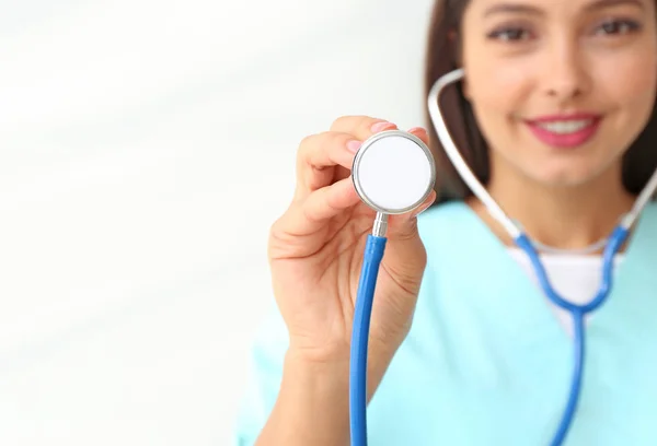 Female cardiologist with stethoscope on light background, closeup — Stock Photo, Image