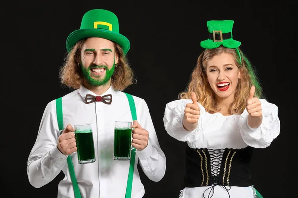 Young couple with beer on dark background. St. Patrick's Day celebration — Stock Photo, Image