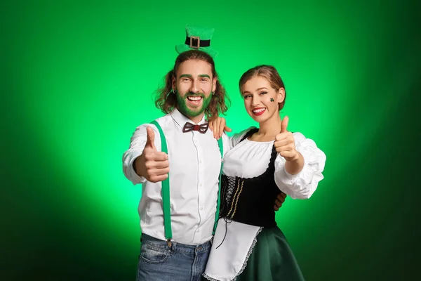 Young couple showing thumb-up on color background. St. Patrick's Day celebration — 스톡 사진