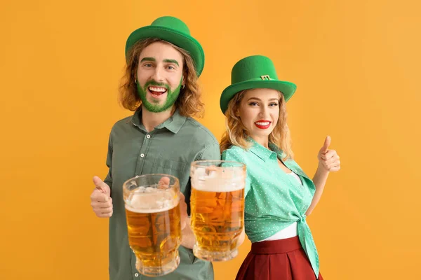 Casal jovem com cerveja no fundo da cor. Celebração do Dia de São Patrício — Fotografia de Stock