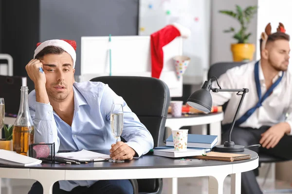 Young man with hangover after New Year party in office — Stock Photo, Image