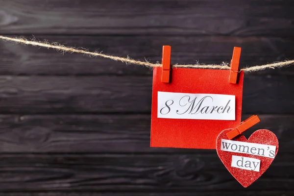 Вітальна листівка на Міжнародний жіночий день, що висить на мотузці на дерев'яному фоні — стокове фото