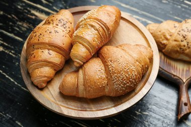 Ahşap masa üzerinde lezzetli kruvasan ile plaka