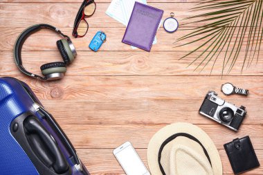 Ahşap arka planda erkek aksesuarları ve bavul. Seyahat kavramı