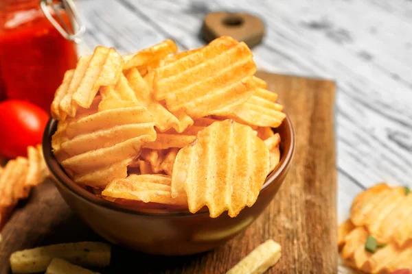 Bowl with tasty potato chips on table — Stock Photo, Image