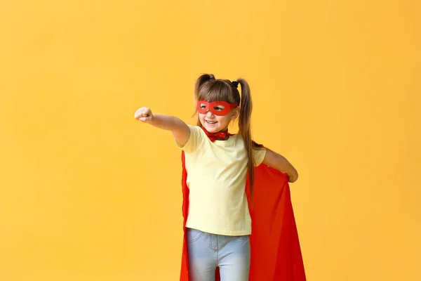 Little girl in superhero costume on color background. Concept of feminism — Stock Photo, Image