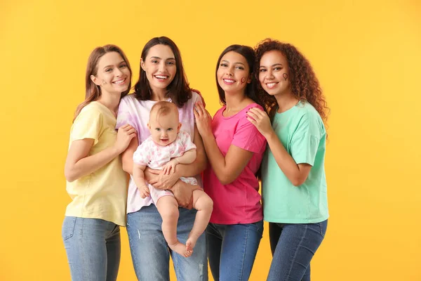 Mujeres jóvenes con bebé sobre fondo de color. Concepto de feminismo — Foto de Stock