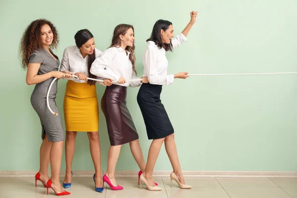 Unga kvinnor drar rep mot färgväggen. Begreppet feminism — Stockfoto