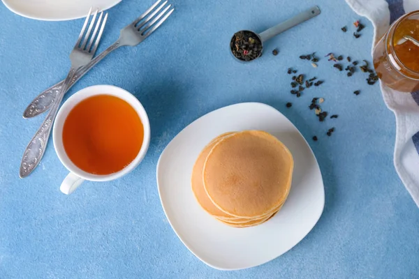 Piring dengan pancake lezat dan teh di atas meja — Stok Foto