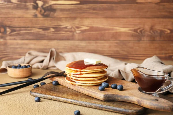 Board with stack of tasty pancakes on table — Stock Photo, Image