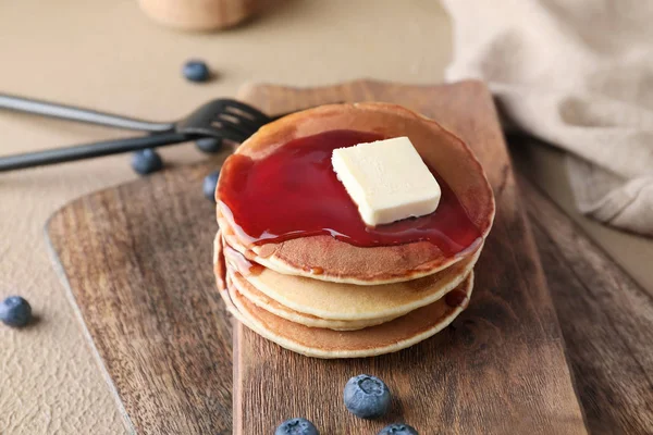 Papan dengan tumpukan pancake lezat di atas meja — Stok Foto