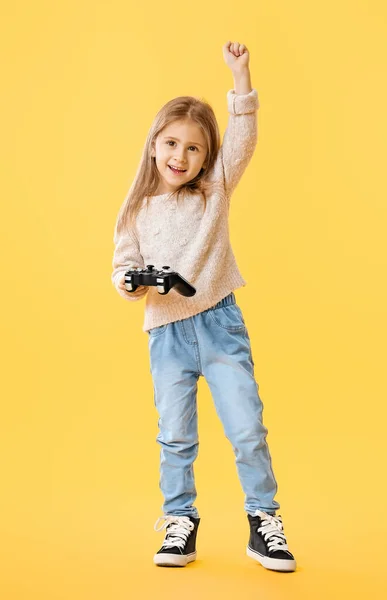 Feliz niña jugando videojuegos en el fondo de color — Foto de Stock