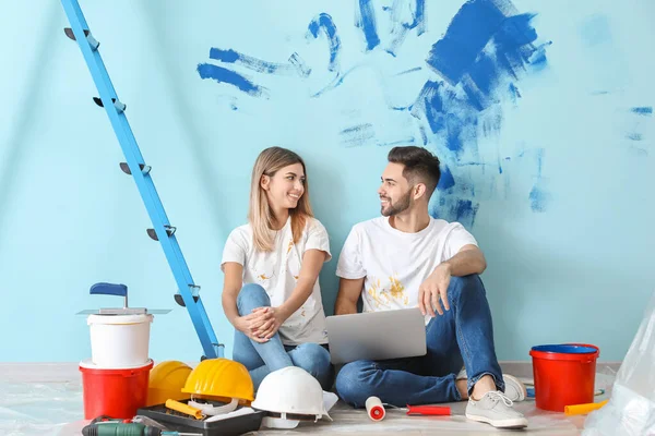 Jovem casal feliz com laptop encomendar materiais para reparação em sua nova casa — Fotografia de Stock