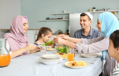 Müslüman bir aile evde yemek yiyor.