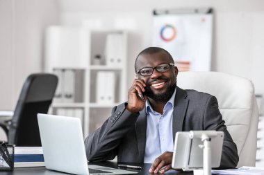 Modern ofiste çalışan yakışıklı Afro-Amerikan iş adamı