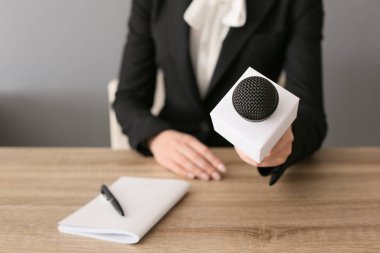 Mikrofonlu kadın gazeteci ofiste röportaj yapıyor, yakın plan.