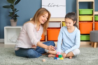 İçeride küçük bir kızla çalışan psikolog.