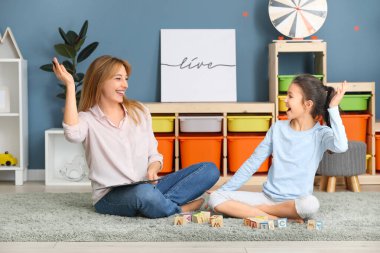 İçeride küçük bir kızla çalışan psikolog.