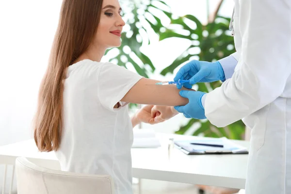 医生在诊所给年轻妇女接种疫苗 — 图库照片