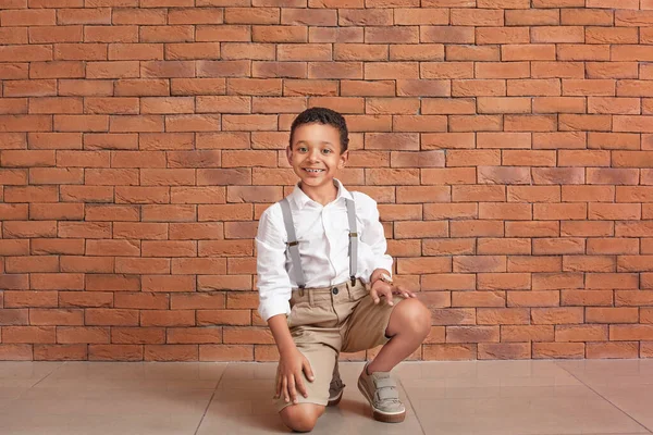 Lindo chico afroamericano de moda cerca de la pared de ladrillo — Foto de Stock