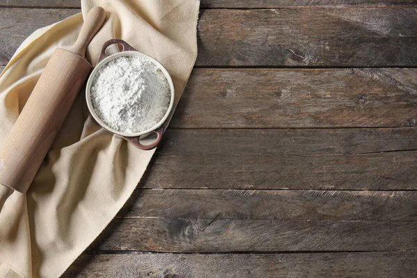 Pot with flour and rolling pin on wooden table — Stock Photo, Image